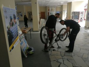 Policjant ze studentem naprawiający rower