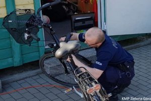 fotografia kolorowa, policjant znakuje rower