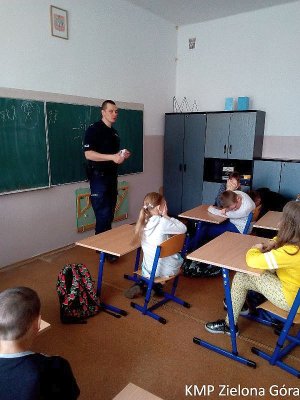 zdjęcie kolorowe, policjant na spotkaniu z uczniami w szkole