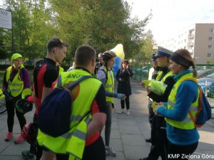 fotografia kolorowa, policjanci rozmawiają z grupą rowerzystów