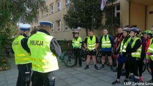 fotografia kolorowa, policjanci ruchu drogowego rozmawiają z grupą rowerzystów