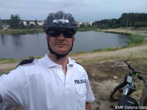 Zdjęcie policjanta stojącego przy rowerze