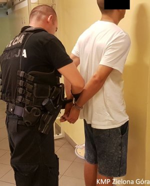 Policjant zakładający kajdanki aresztowanemu mężczyźnie