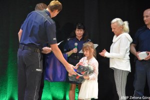 Policjanci wręczają nagrodę dziewczynce