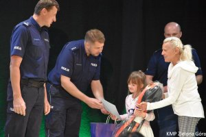 Policjanci wręczają nagrodę dziewczynce