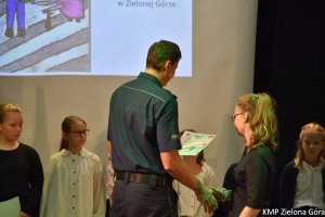 Policjanci wręczają dyplom dziewczynce