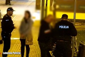 Dwóch policjantów spisuje kobietę i trzech mężczyzn