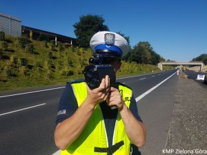 Zdjęcie policjanta mierzącego prędkość pojazdów