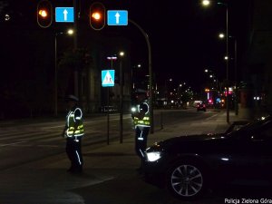 Policjanci stojący przy drodze z miernikiem prędkości