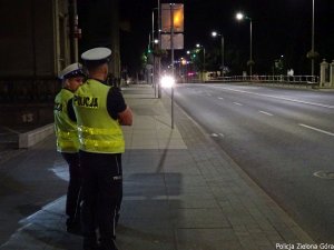 Policjanci stojący przy drodze pilnują aby kierowcy nie przekraczali dozwolonej prędkości
