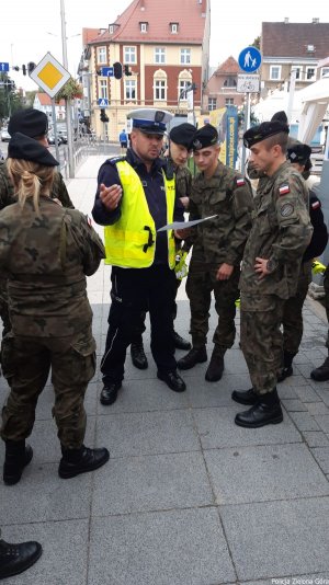 Policjant Ruchu Drogowego rozmawia z żołnierzami