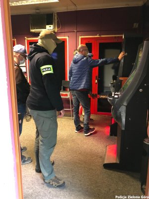 Policjanci przy nielegalnych automatach do gier hazardowych.