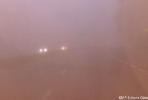 Słabo widoczne światła przednie i tylne samochodów we mgle