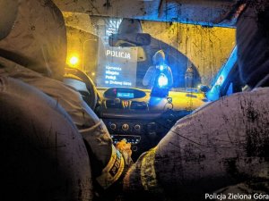 Dwóch policjantów siedzi w radiowozie i patrzy przed siebie