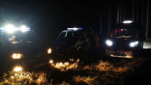 na zdjęciu widoczne są radiowóz policji i wóz bojowy straży pożarnej z włączonymi światłami. Zdjęcie zrobione jest w nocy.