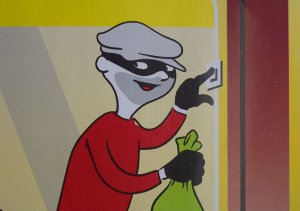 Kreskówkowa postać złodzieja w masce na oczach i workiem na skradzione przedmioty