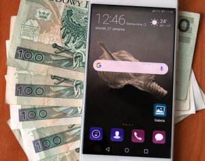 Smartfon leży na pieniądzach