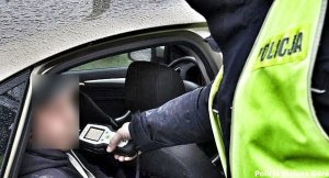 Policjant dokonujący pomiaru trzeźwości u kierowcy