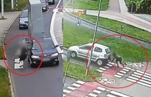 na zdjęciu widać czarny samochód, który potracił pieszego oraz srebrny samochód, który potracił rowerzystę
