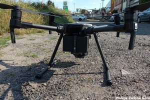 czarny dron stojący na drodze szutrowej