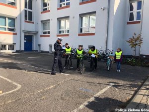 Policjantka Ruchu Drogowego rozmawia z uczniami przed egzaminem na kartę rowerową